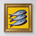 Straight-on view of an original three fish painting on a yellow background in an ornate gold frame